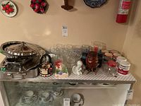 Photo of overall kitchenware lot including metal trays, glassware, ceramic mugs, and decorative jars
