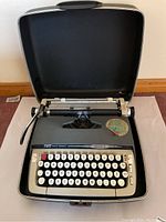 SCM Smith Corona Galaxie II portable typewriter in an open black hard carrying case showing the keyboard and carriage.