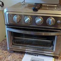 Front view of Cuisinart AirFryer Toaster Oven with control knobs and glass door, showing trays inside