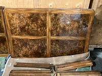 Dining table leaves showing wood inlay with dark, swirling grain pattern and rectangular shape.
