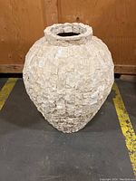 Full view of the large ceramic planter showing its shape and textured exterior tile pattern.