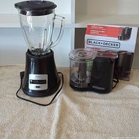 Front view of Oster blender and Black+Decker Fresh Prep chopper with its box behind.
