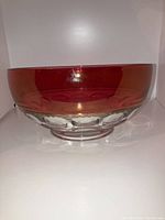Side view of the vintage ruby red Kings Crown Thumbprint bowl showing the red to clear glass transition and scalloped clear base