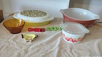 Photo showing all items including the Pyrex Verde Olive divided dish, Harvest Wheat mixing bowl, Pyrex Friendship casserole, amber bowl, tea bag dish, bean slicer, and corn cob holders.