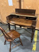 Front view of solid wood vintage writer's desk with attached small drawers and matching chair, showing overall condition and writing surface.