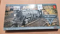 Top view of closed box showing black steam locomotive on railway tracks, Forest background, Big 10 Express branding.