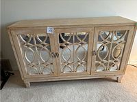 Front view showing three mirrored doors with overlapping rhombus and circle wooden lattice pattern and metal pull-ring handles.