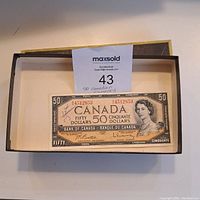 Front of the 1954 Canadian fifty-dollar banknote with box and MaxSold tag.