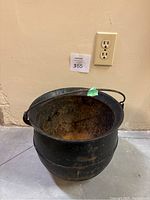 Front and side view of hanging cast iron cauldron showing its size and shape.