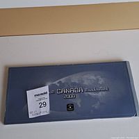 Closed packaging folder showing 'Millennium Canada Millénaire 2000' text and Earth design.