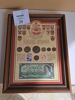 Full view of framed Centennial Collection with coins, banknote, and stamps, showing all contents
