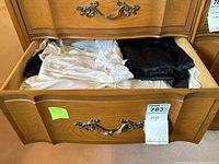 Drawer open showing top view of white and black slips folded side by side.