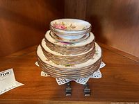 Stacked set of Royal Albert American Beauty china including plates and bowls, showing size and quantity.