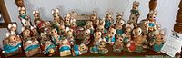 Group photo showing entire collection of 32 hand painted stoneware Woodlanders figurines. Various anthropomorphic mice and rabbits, some holding items or in pairs, arranged on surface.