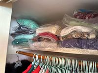 Shelved knit sweaters wrapped in plastic in neutral and pastel colors, showing the variety of styles and colors in the lot.