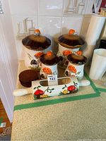 Group photo showing 4 mushroom-themed canisters, 6 round wooden coasters, and the mushroom rolling pin planter on a kitchen counter.