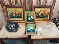 Five framed and decorative pieces displayed on bench