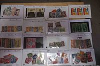 Wide view showing 16 cards of collectible stamps arranged on a table, featuring various colors and countries.
