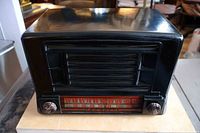 Front view of the 1946 Admiral black bakelite radio showing speaker grille, tuning dial with frequency markings, and two control knobs.