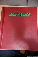 Front cover of red Canada stamp album with green label 'CANADA STAMP ALBUM'