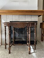 Front view of antique wooden parlor table showing six turned legs and carved apron detail.