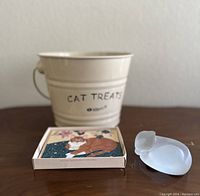 Full lot arranged with cat treat bucket, card box, and frosted cat glass on wooden table.