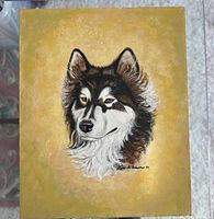 Full view of the oil painting with a husky dog portrait on a golden-yellow background signed by Lou Kline '71.