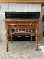 Front view of the vintage Lexington wooden side table showing the drawer and detailed turned legs.