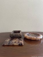 Three vintage sage marble items displayed on a wooden surface: rectangular tray, small rectangular box, and round dish.