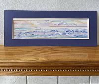 Front view of the framed watercolor seascape painting showing waves and birds, with a navy blue mat and cream border.