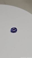 Natural oval cut Tanzanite gemstone on a plain background to show color and cut.