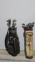 Wide view showing the two golf bags and their contents, highlighting the different bag styles and club types.
