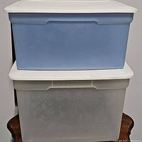 Front view of stacked blue and white plastic storage bins with lids