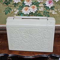 Sewing machine carrying case with embossed rose design on front