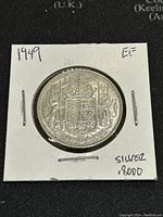 Front side of the 1949 Canadian silver 50 cent coin showing the Canadian coat of arms with 'CANADA 1949' engraved and 'SILVER .8000' noted on the holder.