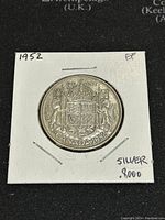Obverse side of the 1952 Canadian silver 50 cents coin showing the crowned Canadian Coat of Arms, date 1952 and markings indicating 80% silver composition and EF condition.