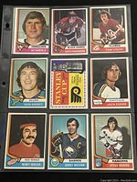 Front of the 9 assorted 1974-75 O-Pee-Chee NHL hockey trading cards displayed in a plastic sleeve.