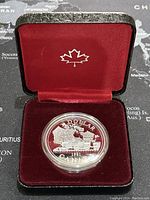 Silver commemorative coin dated 1981 featuring the Trans-Canada Railway steam locomotive inside its original red velvet-lined display case with a white maple leaf emblem on the inside lid.