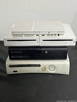 Stacked view of all five consoles: PS2 slim on top, two Wii consoles in the middle, two Xbox 360 consoles on bottom.