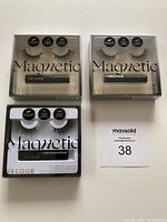 Three Velour Magnetic Lash Kits on a white surface. Each kit contains a pair of black magnetic false eyelashes and a tube of adhesive in clear plastic packaging.