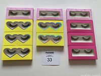 Complete set of 11 pairs of full band false lashes in their packaging: 3 pairs in pink box, 8 pairs in yellow heart-shaped box, all brand new.