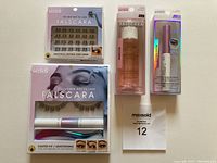 Photo showing the full set of Kiss Falscara items including the Starter Kit, Multipack Natural Wispy Wisps, Remover, and Overnighter adhesive in original packaging.