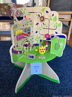 Front view showing bead maze, colorful sliders, and painted monkey and butterfly designs.