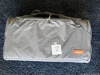 Closed carrying bag for the Milliard foldable travel memory foam mattress. Gray fabric with handles and zipper, Milliard brand label visible.