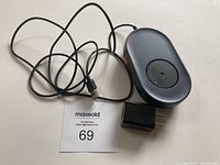 Item laid out showing the device, USB cable, and wall adapter plug with lot number card