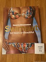 Cover of Sports Illustrated Swimsuit 50 Years of Beautiful coffee table book showing a woman in a colorful bikini and the book title.