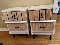 Photo of two vintage nightstands side-by-side showing textured vertical groove fronts, white tops, black handles, and black legs on hardwood floor.
