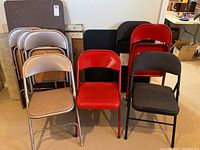 Front view showing card tables and three types of folding chairs in beige, red, and black colors.