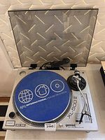 Front angle photo of the Gemini XL-500 II turntable with open dust cover and blue International House Records slipmat visible on the platter.