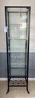 Front view of the IKEA Klingsbo glass display cabinet with black metal frame, glass door closed.